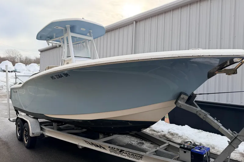 Slide: The Image of 2018 Tidewater 232 SS boat on trailer, parked near a building in snowy conditions. - 2