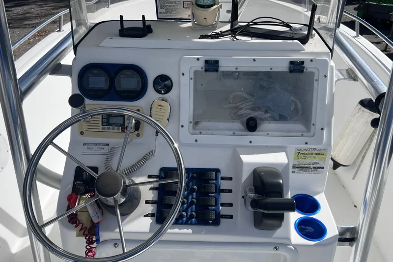 Slide: The Image of Center console of a 2001 Cobia 194 boat with steering wheel and controls. - 12