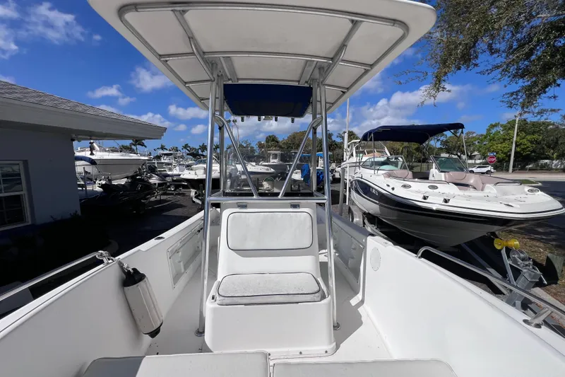 Slide: The Image of 2001 Cobia 194 Center Console boat with T-top, docked under clear blue sky. - 19