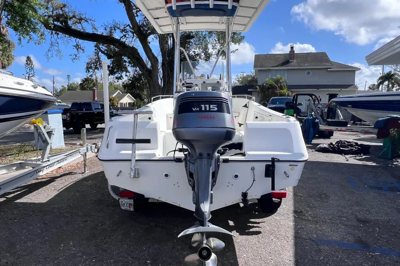 Slide: The Image of 2001 Cobia 194 Center Console boat with Yamaha V4 115 engine, parked outdoors. - 2