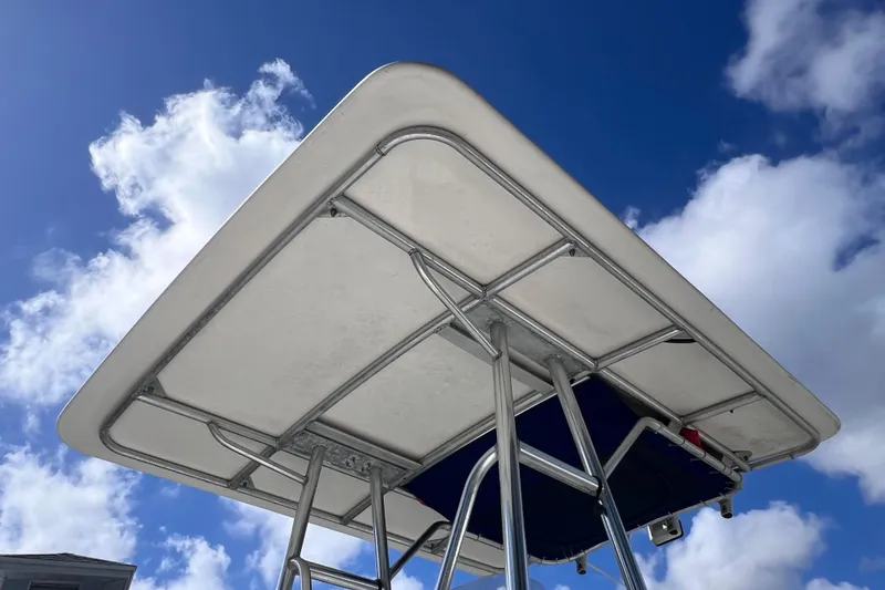 Slide: The Image of T-top of 2001 Cobia 194 Center Console boat against blue sky with clouds. - 6