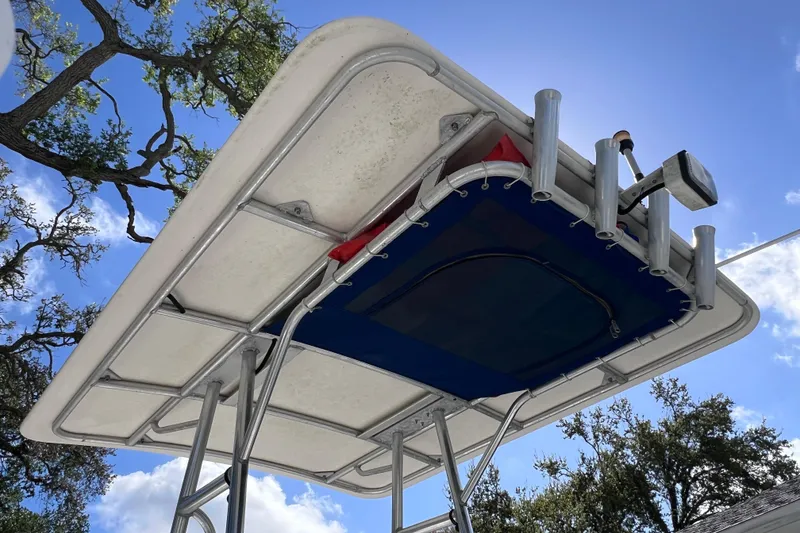 Slide: The Image of T-top of 2001 Cobia 194 Center Console boat against blue sky and trees. - 7