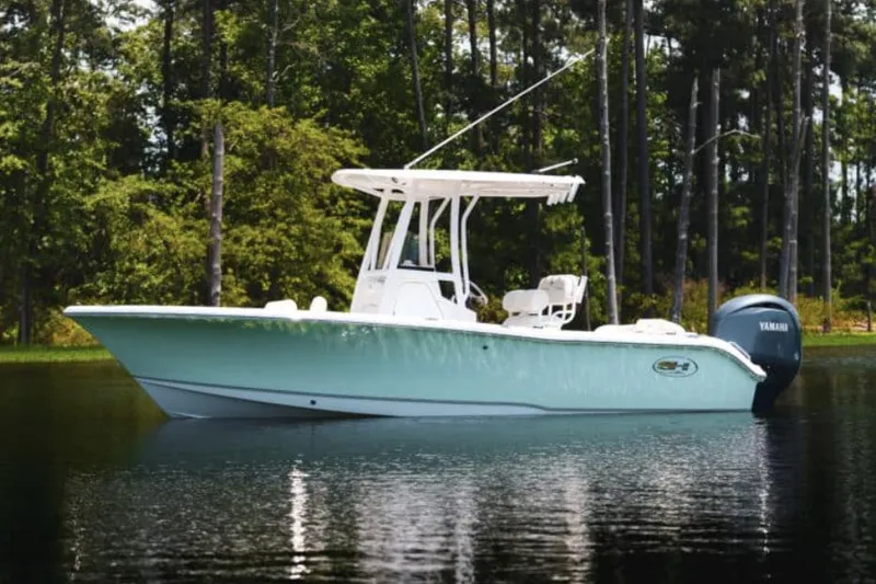 Slide: The Image of Manufacturer Provided Image: 2026 Sea Hunt Ultra 219 boat on calm water, surrounded by trees. - 22