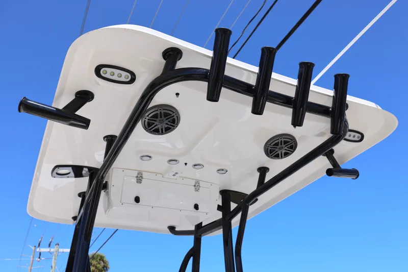 Slide: The Image of T-top of 2026 Sea Hunt Ultra 219 boat with rod holders and speakers against blue sky. - 4