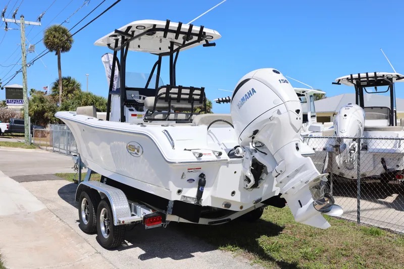 Slide: The Image of 2026 Sea Hunt Ultra 219 boat with Yamaha engine on trailer, parked outdoors. - 7