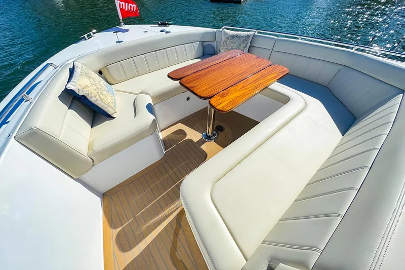 Slide: The Image of Luxurious seating area on 2024 MJM 4 boat with wooden table and cushions. - 10