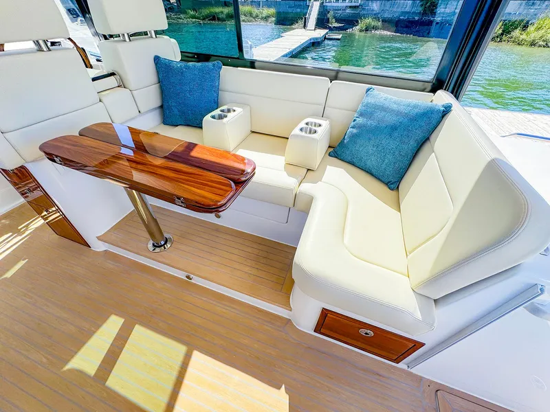 Slide: The Image of Luxurious seating area on 2024 MJM 4 yacht with wooden table and blue cushions. - 21