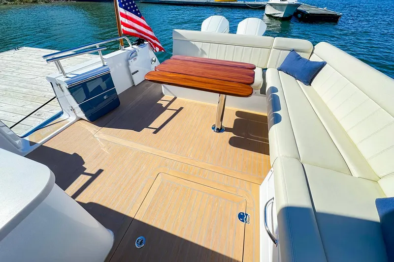Slide: The Image of Luxurious 2024 MJM 4 boat deck with seating, table, and American flag. - 22