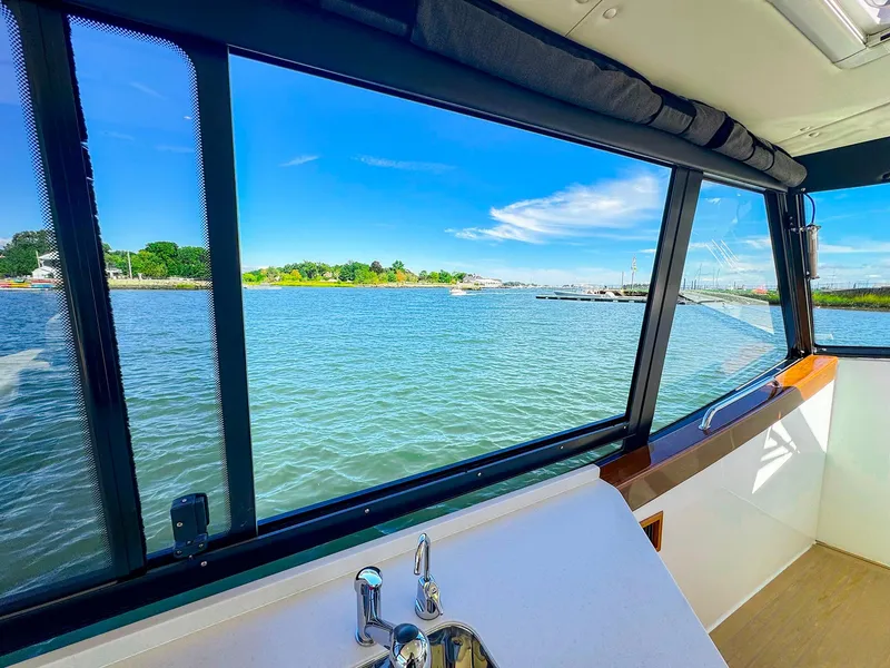 Slide: The Image of View from 2024 MJM 4 boat interior, overlooking serene waters and blue sky. - 6