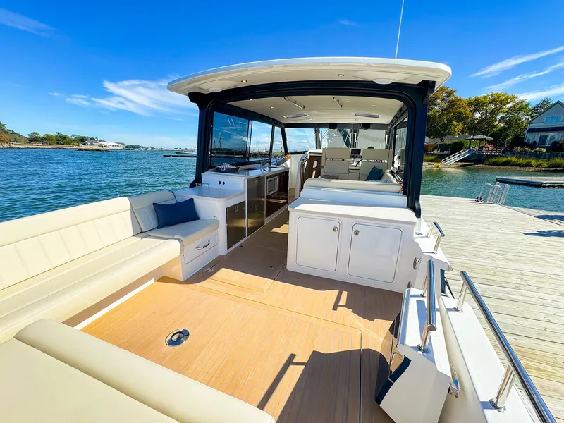 Slide: The Image of 2024 MJM 4 boat with spacious deck and seating, docked by the water. - 7