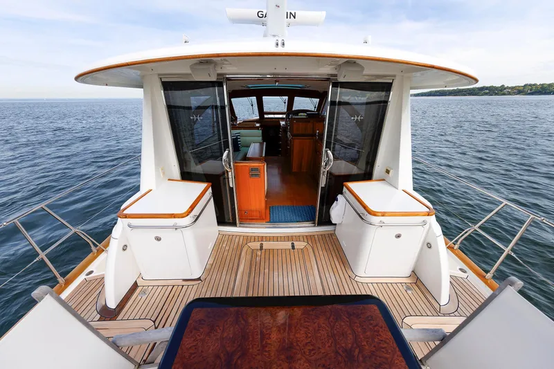 Slide: The Image of 2009 Hunt Yachts 52 Express, elegant deck view with teak flooring and ocean backdrop. - 17