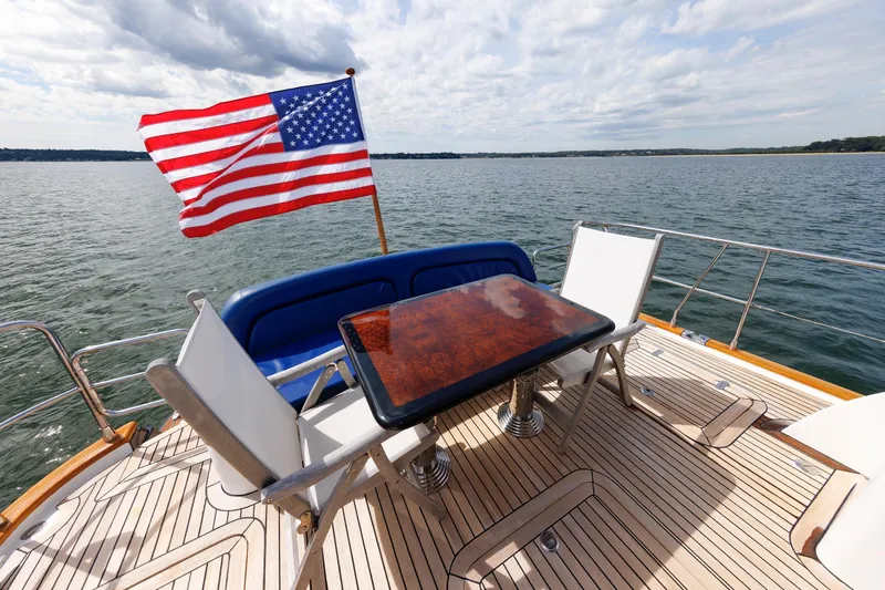 Slide: The Image of 2009 Hunt Yachts 52 Express deck with American flag and seating area on open water. - 21