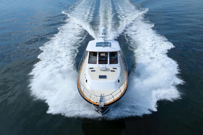 Slide: The Image of 2009 Hunt Yachts 52 Express cruising on open water, creating a dynamic wake. - 57