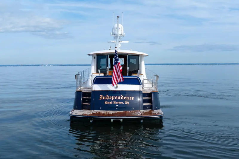 Slide: The Image of 2009 Hunt Yachts 52 Express on calm water, displaying American flag. - 58