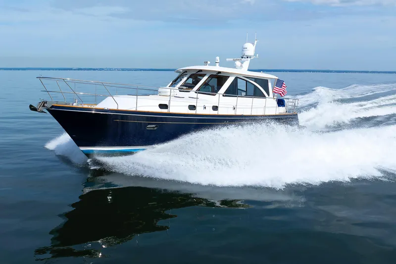 Slide: The Image of 2009 Hunt Yachts 52 Express cruising on calm waters with American flag. - 60