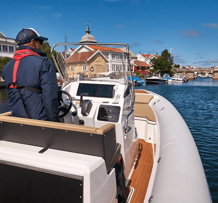 Slide: The Image of 2023 Northstar Orion 7 boat navigating a scenic waterfront with houses and clear skies. - 8