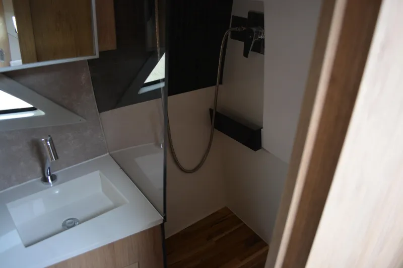 Slide: The Image of Modern bathroom interior of 2026 NX Boats 360 Sport Coupe, featuring sleek sink and shower design. - 13