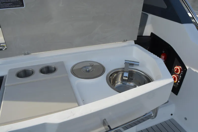 Slide: The Image of Outdoor kitchenette on 2026 NX Boats 360 Sport Coupe with sink and cup holders. - 15
