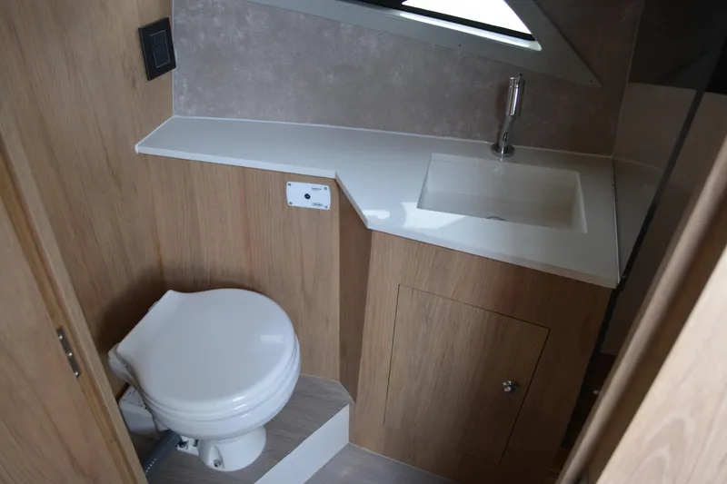 Slide: The Image of Bathroom interior of 2026 NX Boats 360 Sport Coupe, featuring modern sink and toilet. - 16
