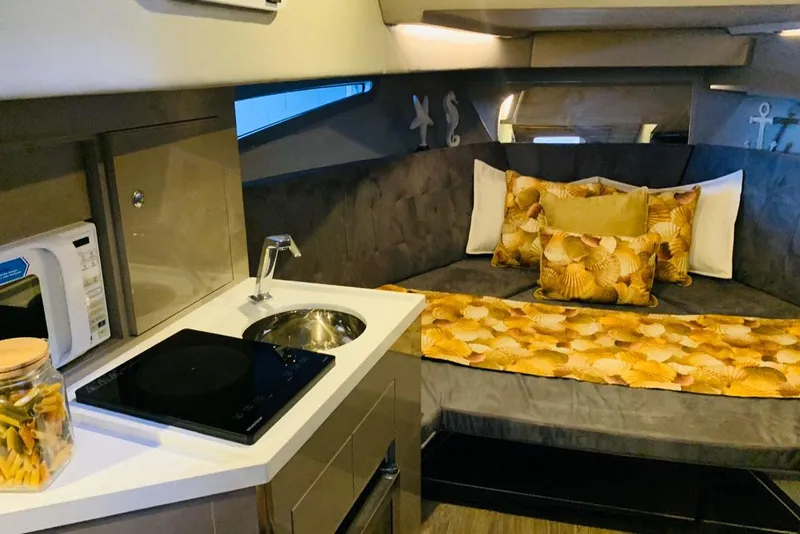 Slide: The Image of Manufacturer Provided Image: Interior of 2025 NX Boats 360 Sport Coupe with cozy bed and kitchenette. - 9