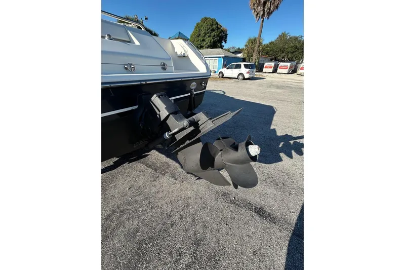 Slide: The Image of 2001 Pursuit 2460 Denali boat propeller and stern, parked on asphalt. - 2