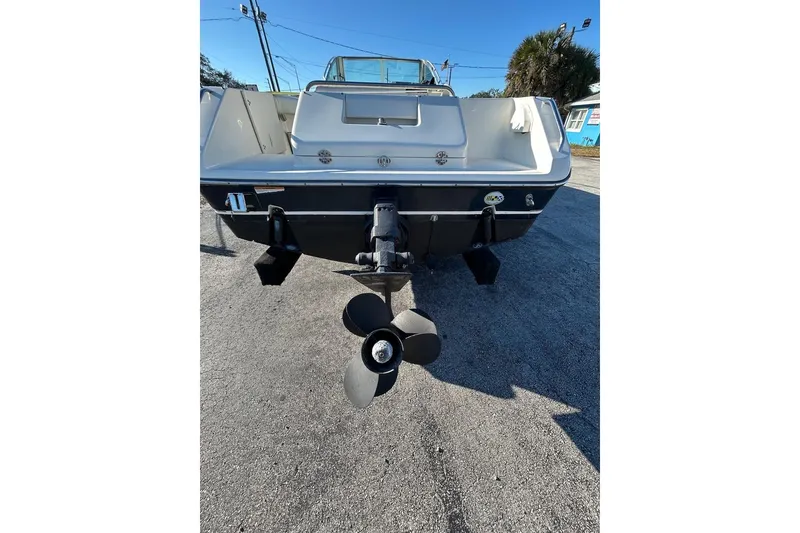 Slide: The Image of 2001 Pursuit 2460 Denali boat rear view with propeller, parked on pavement. - 4