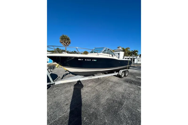 Slide: The Image of 2001 Pursuit 2460 Denali boat on trailer under clear blue sky. - 8