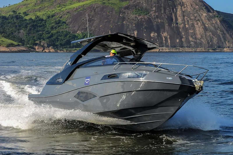 The Image of Manufacturer Provided Image: 2025 NX Boats 290 Exclusive cruising on water, sleek design, mountainous backdrop. - 0