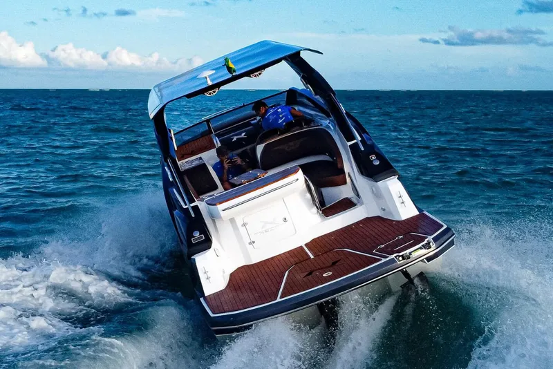 Slide: The Image of Manufacturer Provided Image: 2025 NX Boats 290 Exclusive cruising on open water, showcasing sleek design and performance. - 1