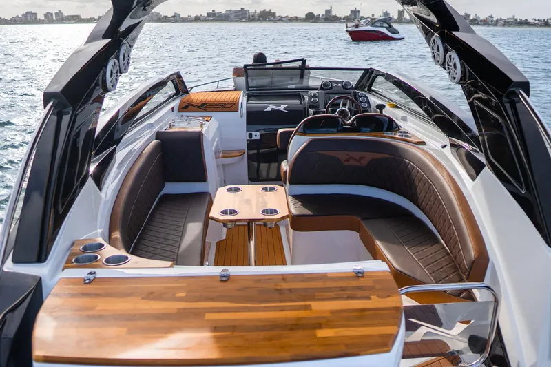 Slide: The Image of Manufacturer Provided Image: 2025 NX Boats 290 Exclusive luxury interior with wood accents on the water. - 3
