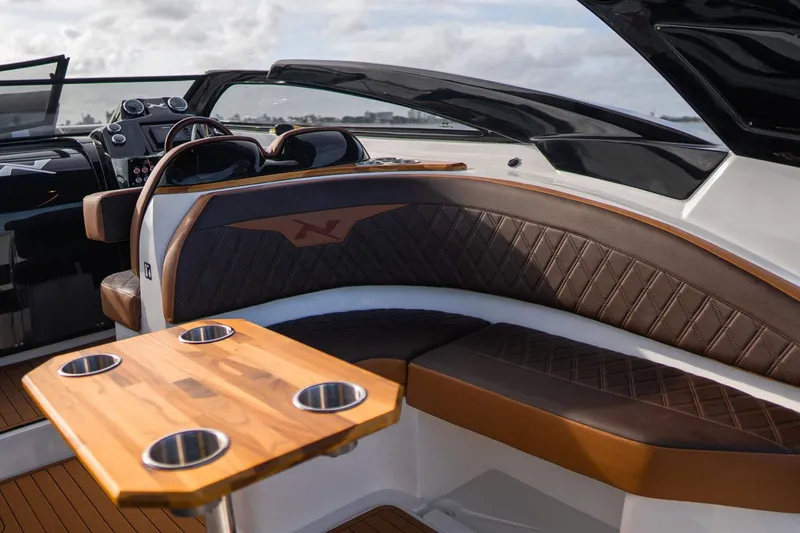 Slide: The Image of Manufacturer Provided Image: 2025 NX Boats 290 Exclusive interior with luxurious seating and wooden table. - 5