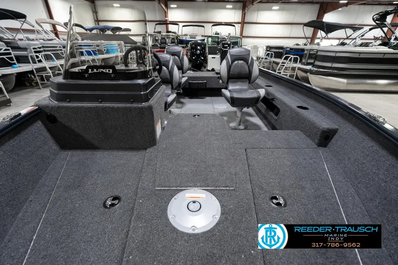 Slide: The Image of 2026 Lund 1775 Adventure SS boat interior with seating and console, displayed in showroom. - 16