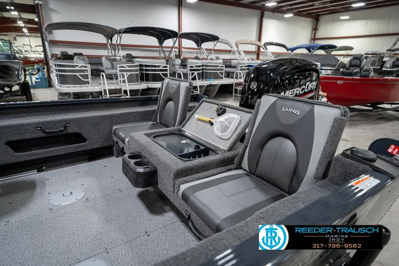 Slide: The Image of 2026 Lund 1775 Adventure SS boat interior with seating and storage, displayed in showroom. - 21