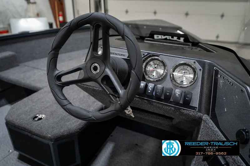Slide: The Image of Steering wheel and dashboard of 2026 Lund 1775 Adventure SS boat, featuring gauges and controls. - 28