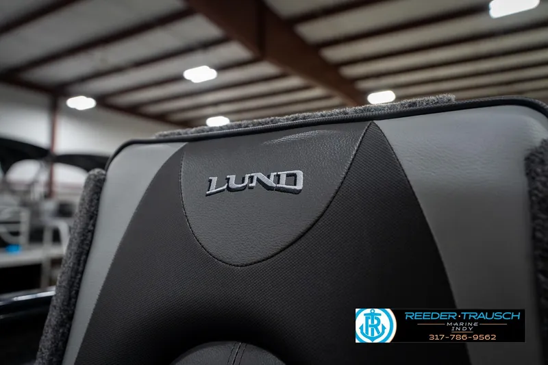 Slide: The Image of 2026 Lund 1775 Adventure SS boat seat with logo in a showroom setting. - 37