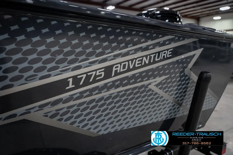 Slide: The Image of 2026 Lund 1775 Adventure SS boat with sleek design and branding in showroom. - 55