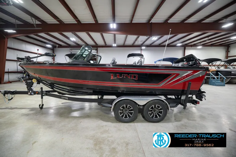 Slide: The Image of 2026 Lund 1975 Tyee boat in showroom, black and red design, on trailer. - 10