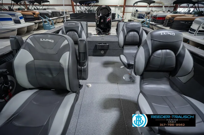 Slide: The Image of 2026 Lund 1975 Tyee boat interior with gray seating in showroom. - 19