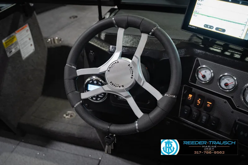Slide: The Image of Steering wheel and dashboard of 2026 Lund 1975 Tyee boat with modern controls. - 30