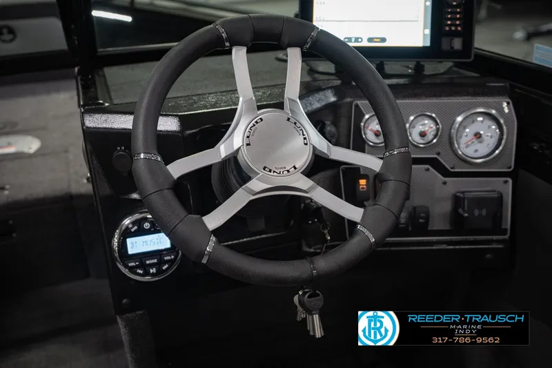 Slide: The Image of Steering wheel and dashboard of 2026 Lund 1975 Tyee boat with gauges and controls. - 31