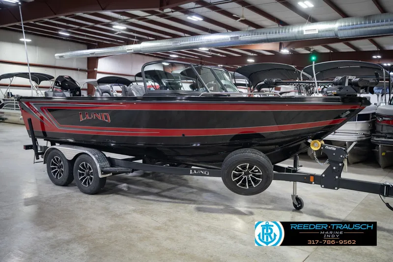Slide: The Image of 2026 Lund 1975 Tyee boat in showroom, black and red design, on trailer. - 5