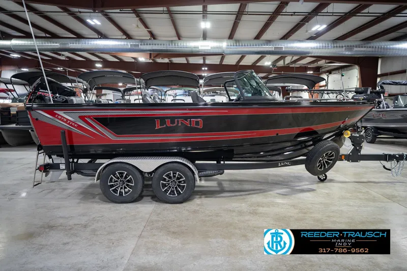 Slide: The Image of 2026 Lund 1975 Tyee boat in showroom, black and red design, on trailer. - 6