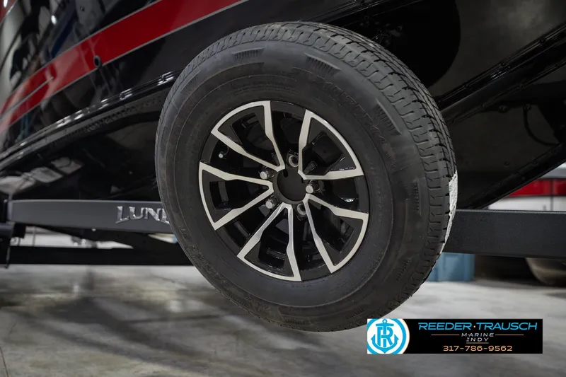 Slide: The Image of 2026 Lund 1975 Tyee boat trailer wheel, black and silver design, Reeder-Trausch Marine logo. - 66
