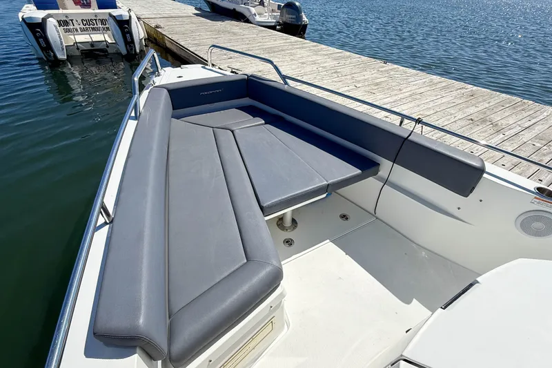 Slide: The Image of 2020 Axopar 28 Cabin boat with gray seating, docked by the water. - 9
