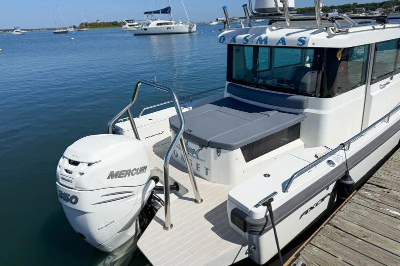Slide: The Image of 2020 Axopar 28 Cabin boat docked with Mercury engine, calm waters in the background. - 3