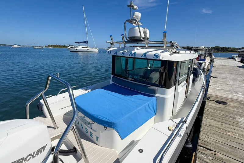 Slide: The Image of 2020 Axopar 28 Cabin boat docked by the water on a sunny day. - 28