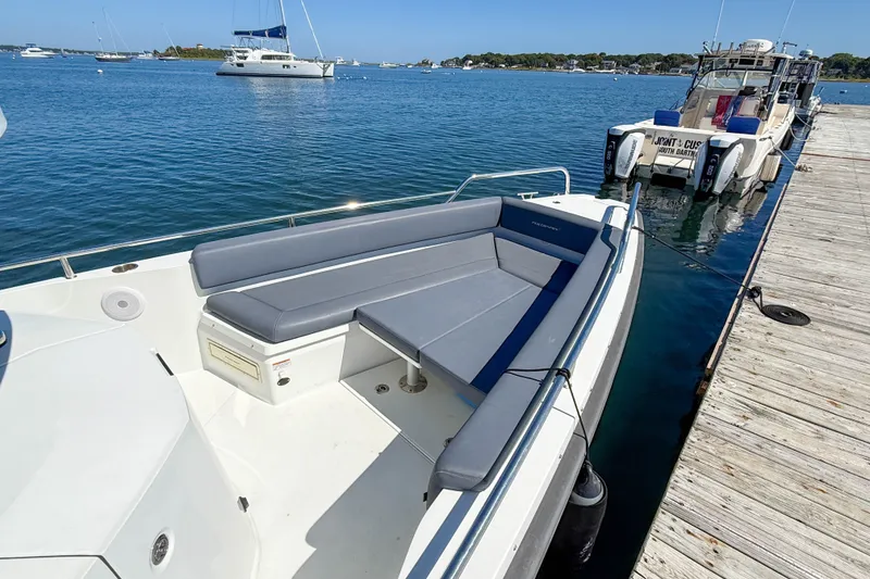 Slide: The Image of 2020 Axopar 28 Cabin boat docked by a wooden pier on a sunny day. - 8