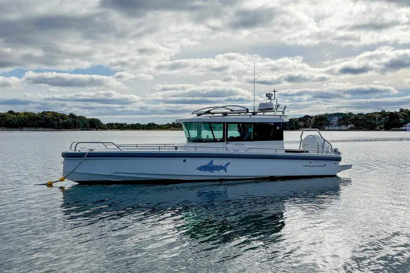 Slide: The Image of 2020 Axopar 28 Cabin boat on calm water under cloudy sky. - 31