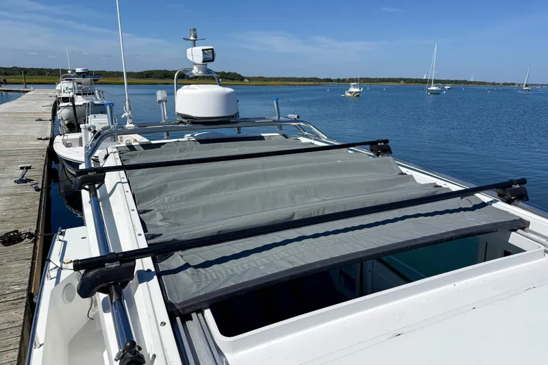 Slide: The Image of 2020 Axopar 28 Cabin boat docked by a serene lake. - 26