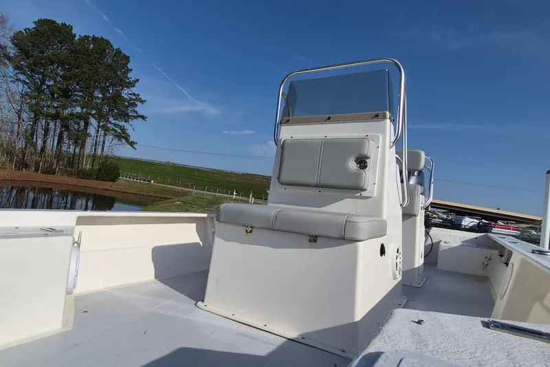 Slide: The Image of 2024 May-Craft 22 Hancock Skiff boat with center console, set against a scenic outdoor backdrop. - 11